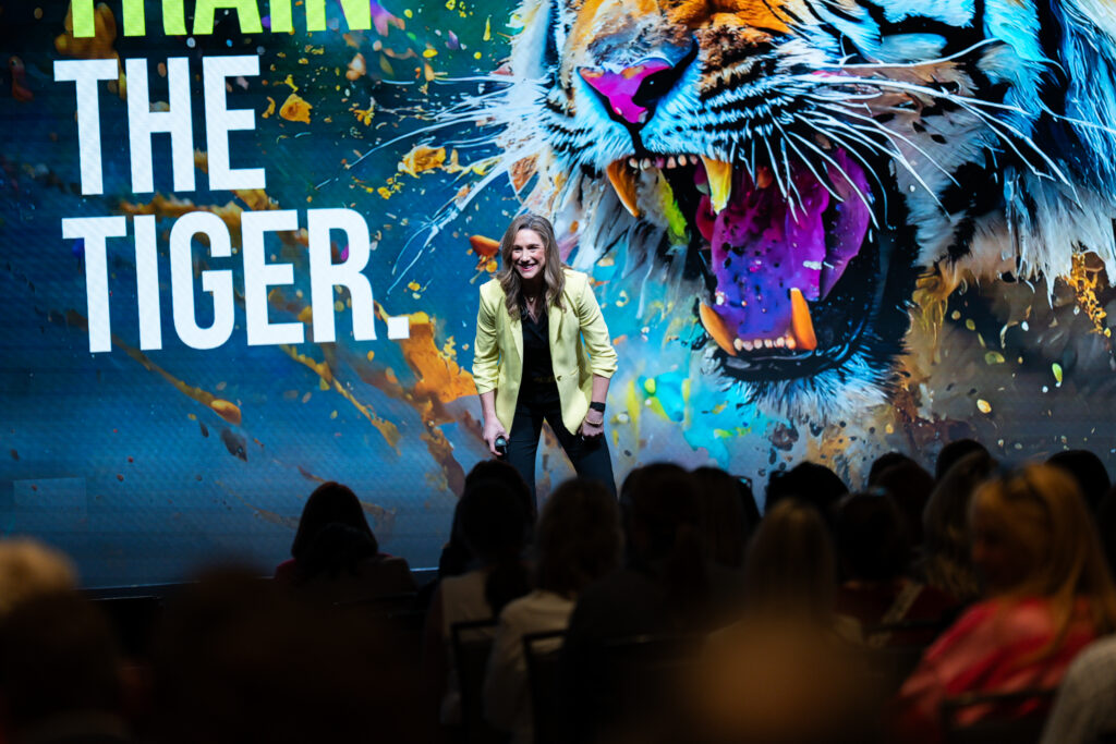 Dr. Rebecca Heiss keynote on training the brain's stress response, with tiger imagery on stage
