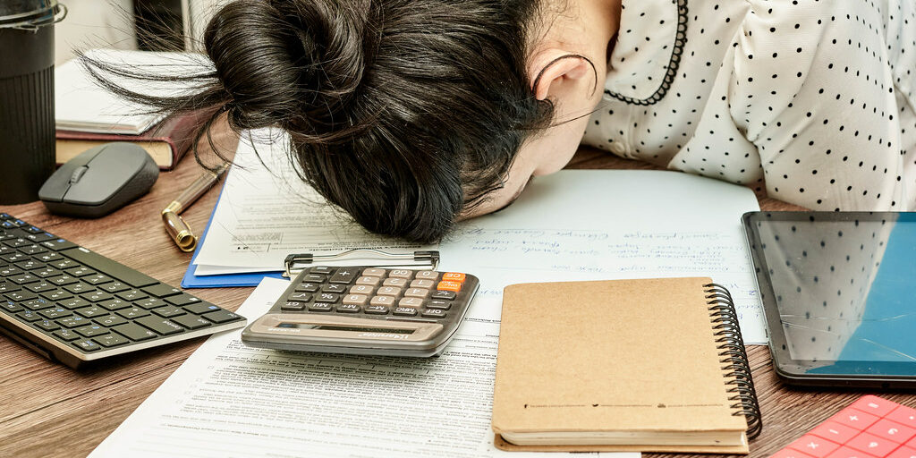 A woman, giving up at her desk